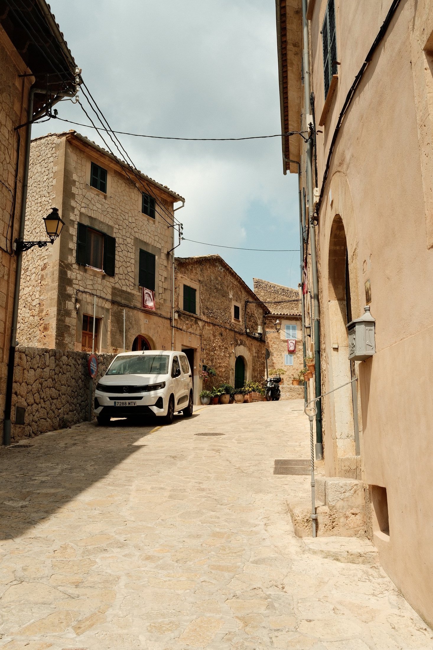 A narrow stone street with a parked van