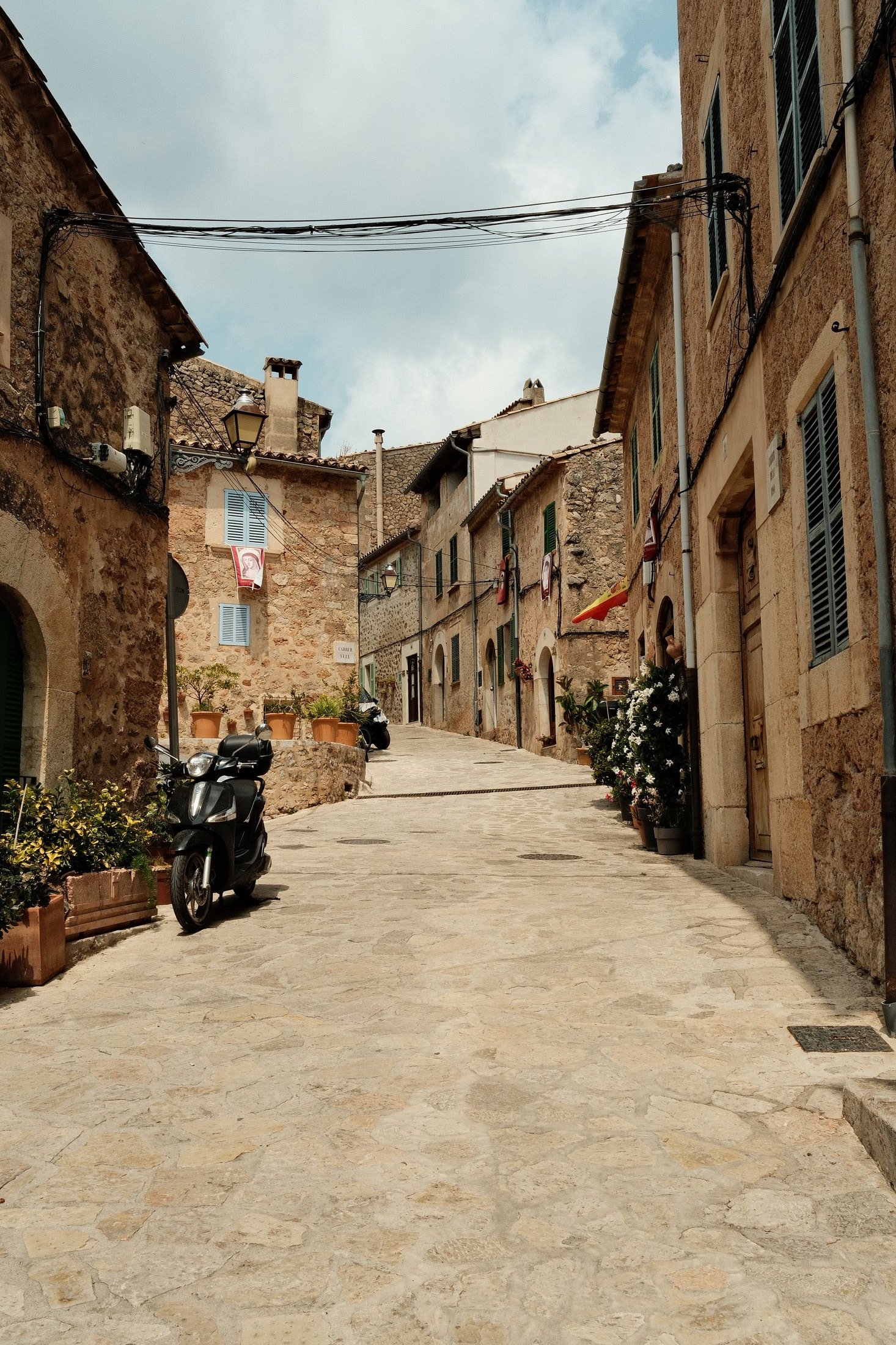 A narrow stone street with a scooter